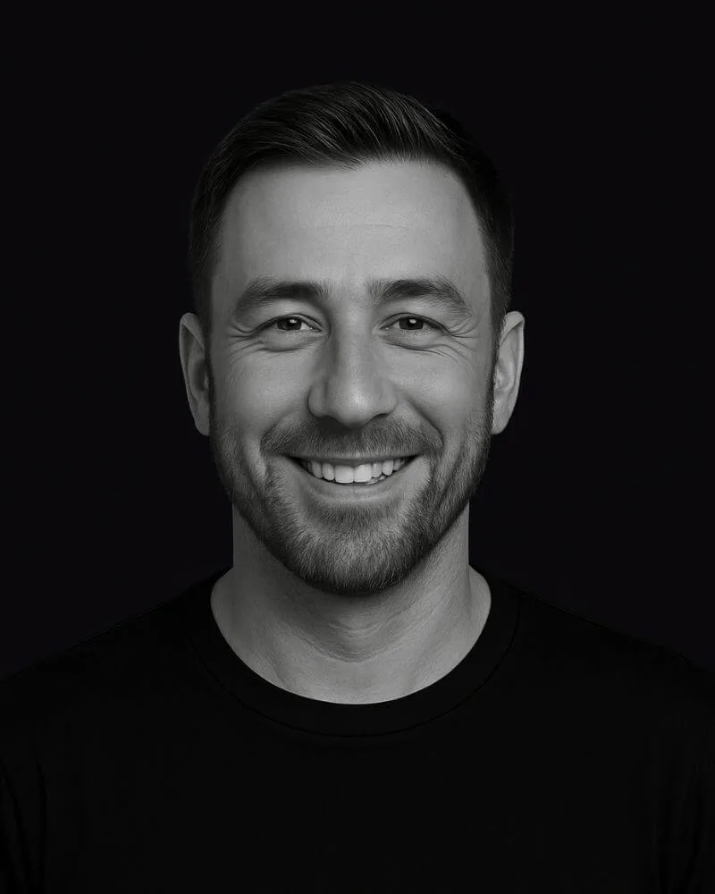 Porträt von Georgios „Gios“ Pilalidis in Schwarz-Weiß, lächelnd